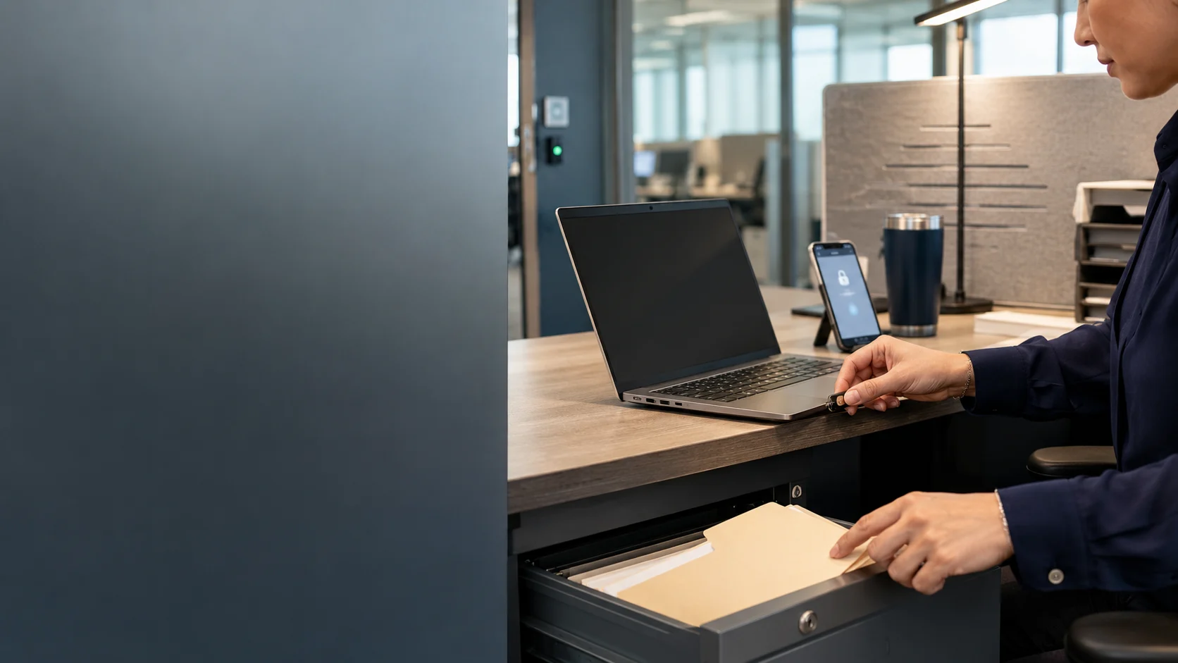 HR professional securely accessing a business laptop while protecting confidential employee records in a commercial office.
