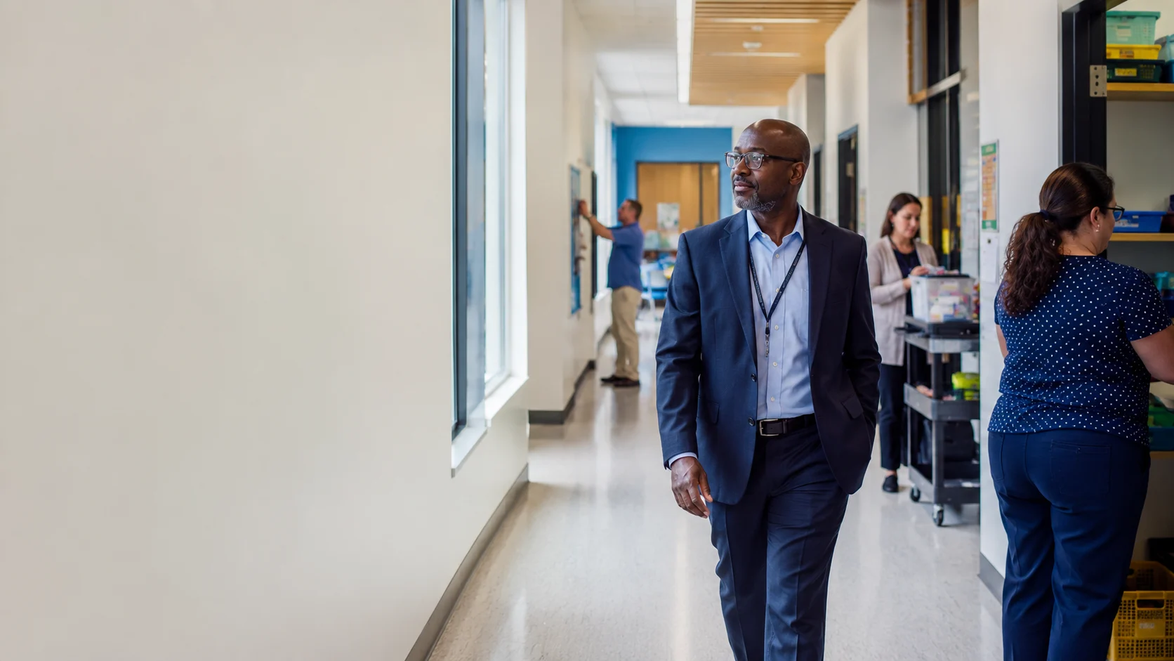 School administrator overseeing teachers and support staff in a modern education facility.