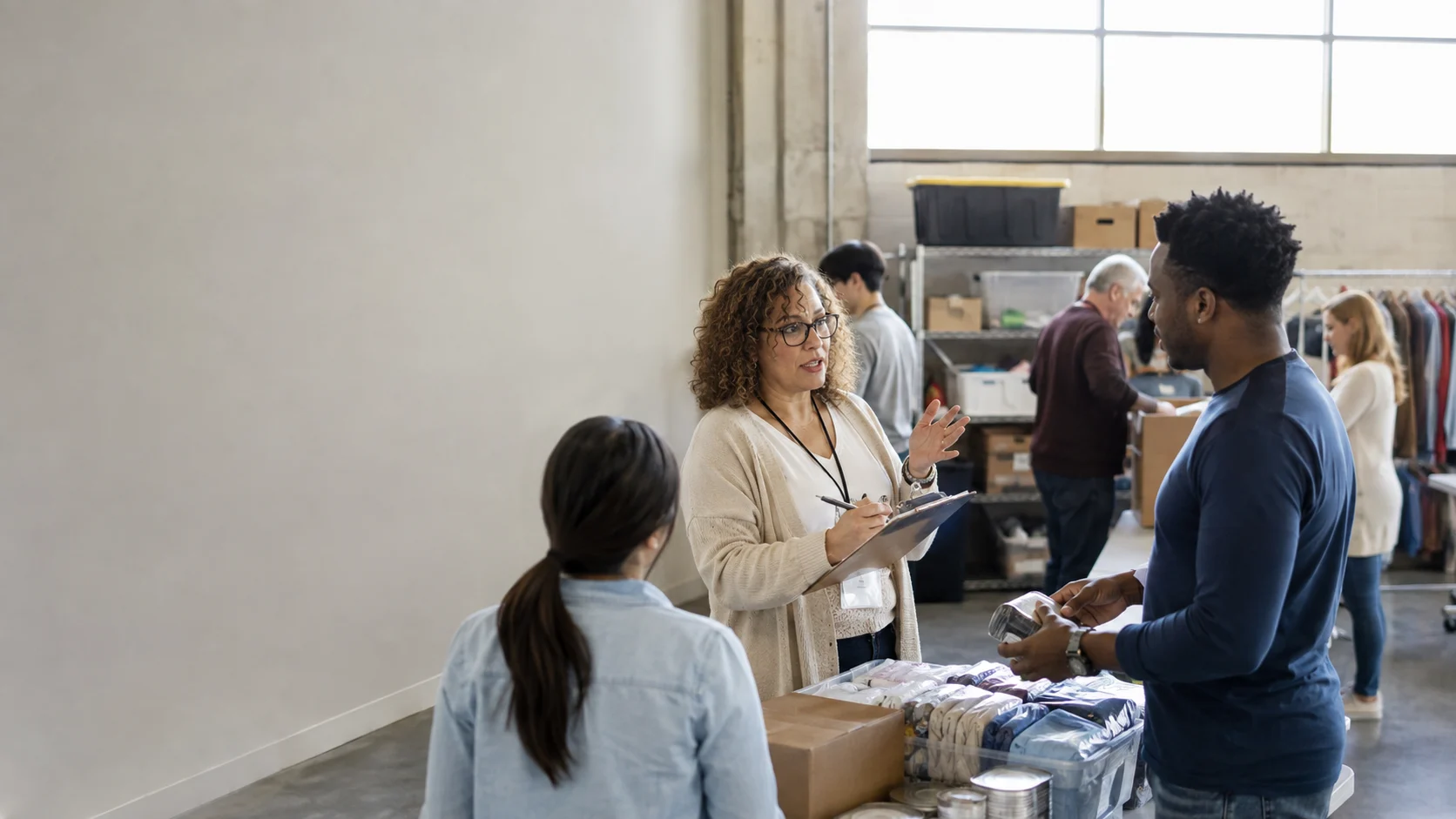 Nonprofit program director coordinating staff and volunteers at a community service center.